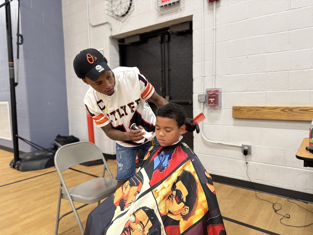 A barber giving a Jackson PreK-8 student a haircut.
