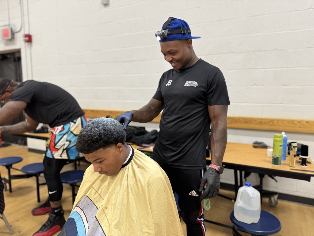 A barber giving a Jackson PreK-8 student a haircut.