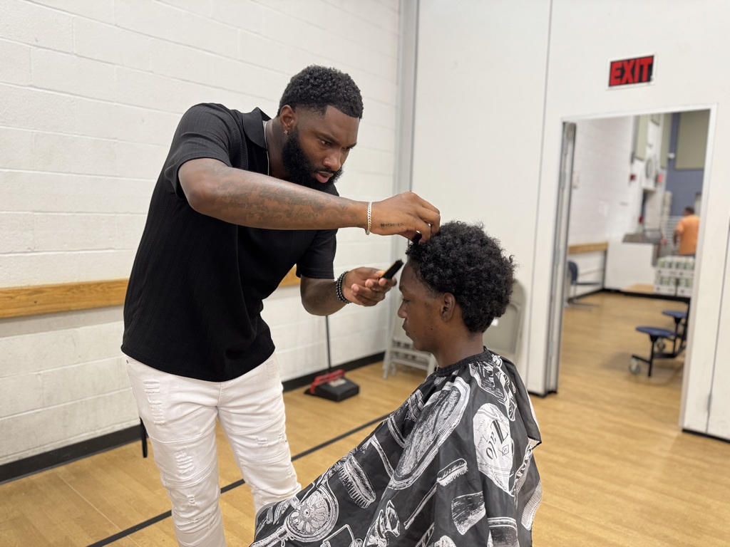 A barber giving a Jackson PreK-8 student a haircut. 