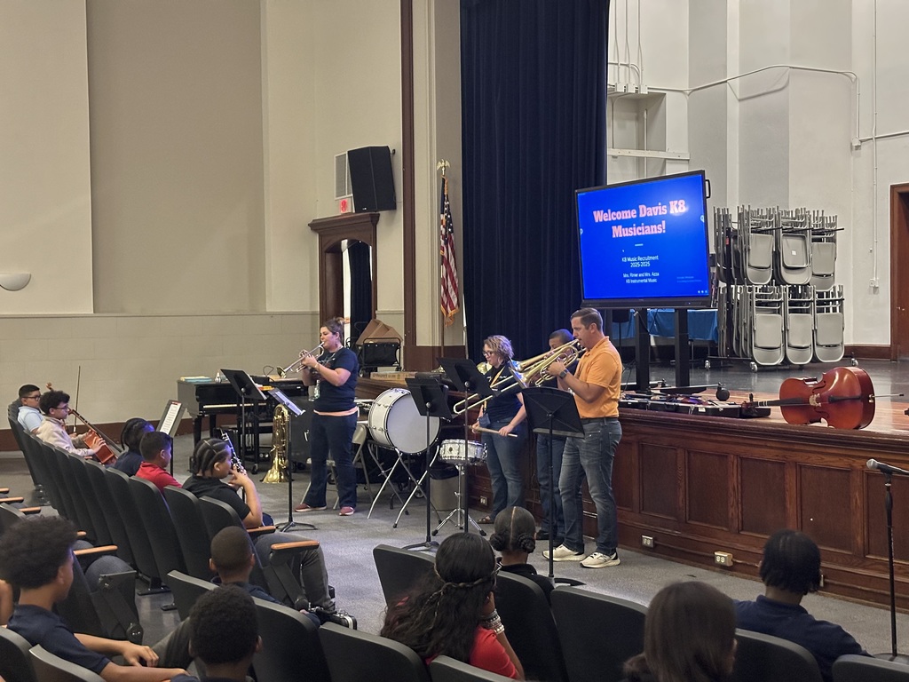 District staff playing instruments at the district's annual K-8 Music Recruitment Assembly.