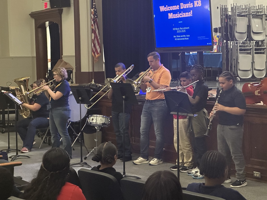 District staff members and students playing instruments during the district's annual K-8 Music Recruitment Assembly.
