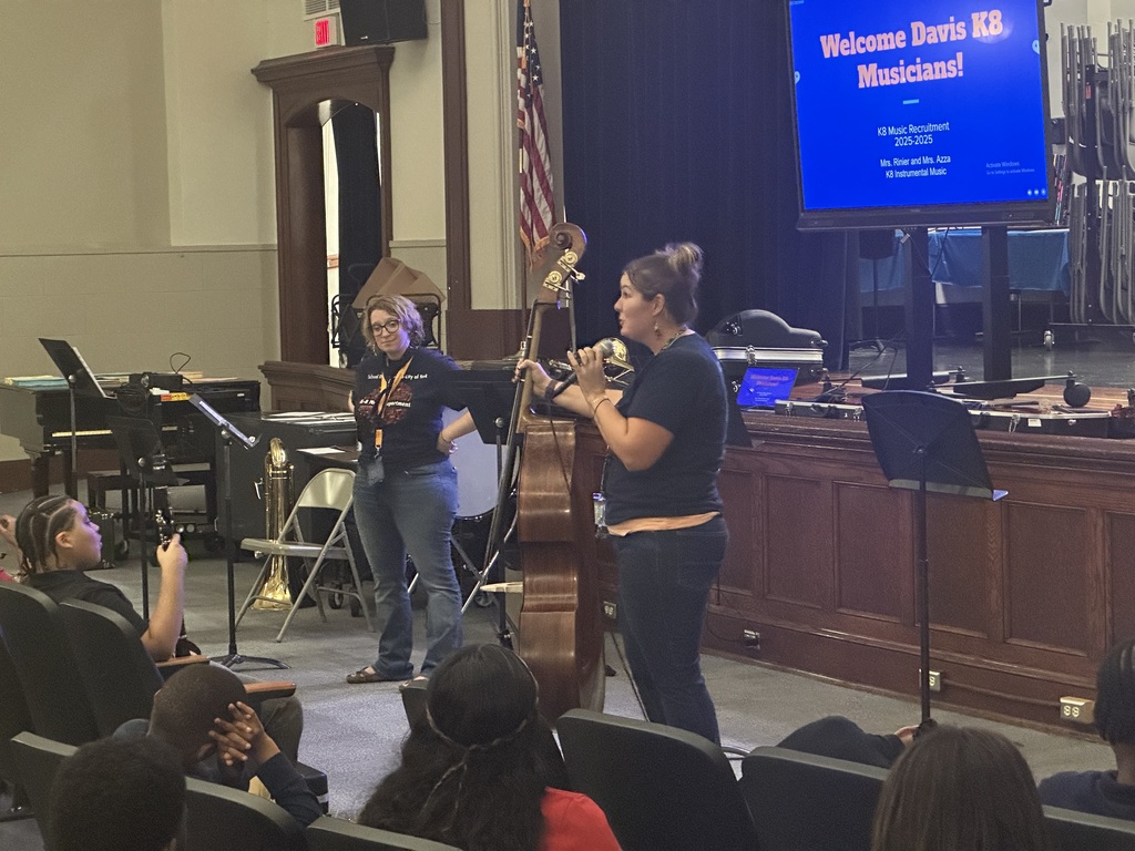District staff member playing an instrument at the district's annual K-8 Music Recruitment Assembly.