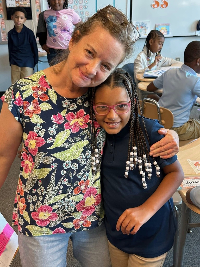 A district staff member with her arm wrapped around a student. 
