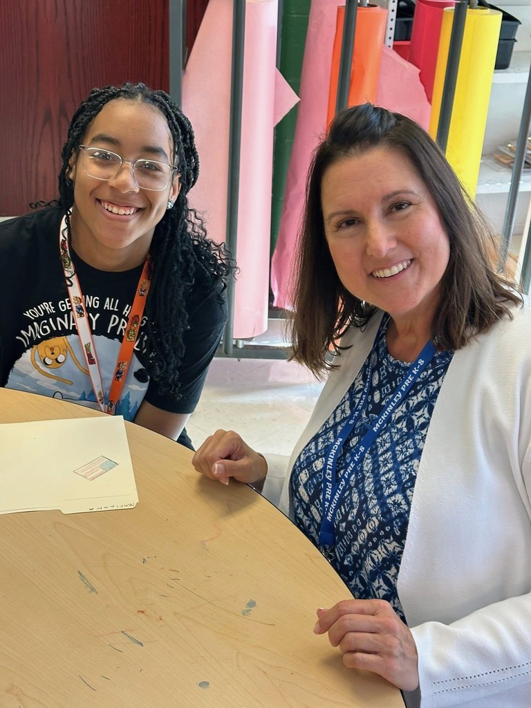A district staff member and a student sitting at a table together.