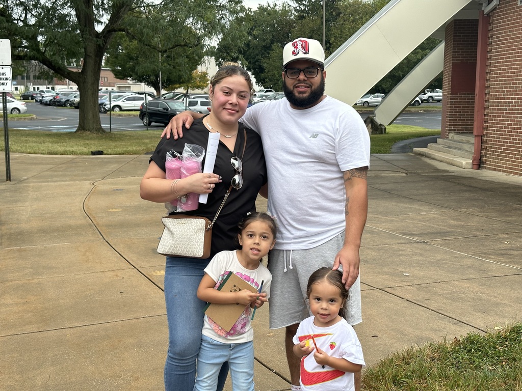 Two adults and two children posing for a photo outside.