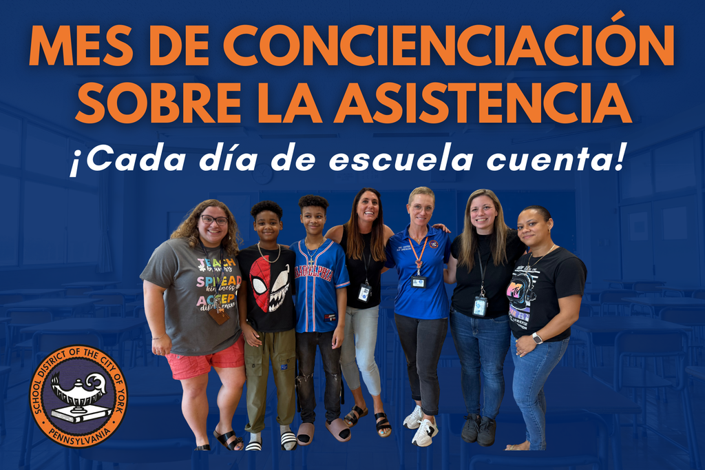 A diverse group of students and staff stands together in a classroom, promoting Attendance Awareness Month with enthusiasm.