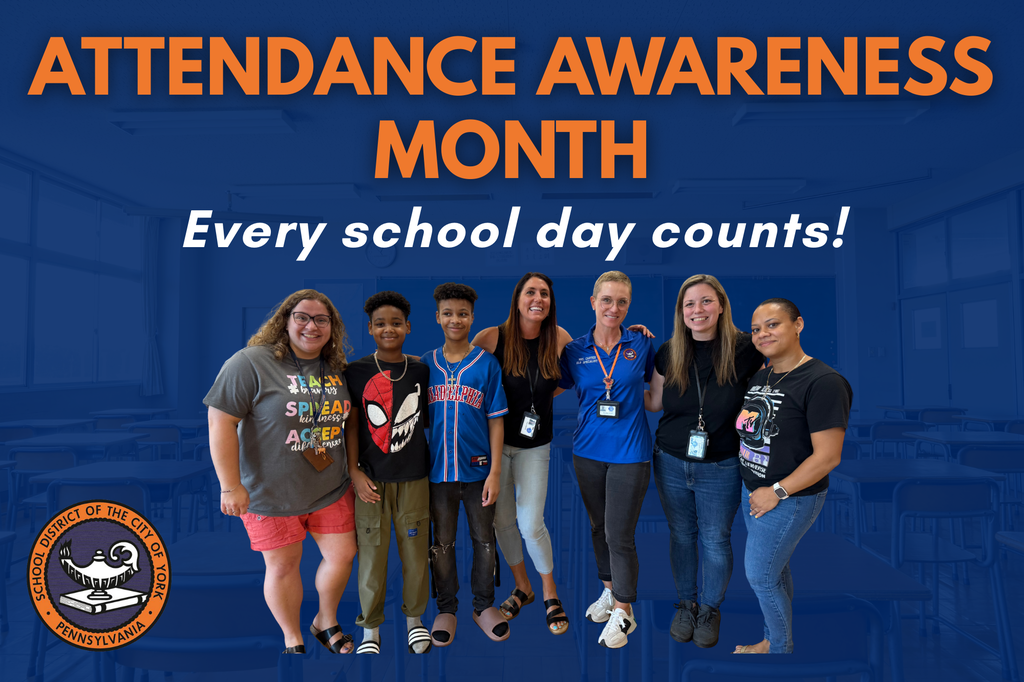 A diverse group of students and staff stands together in a classroom, promoting Attendance Awareness Month with enthusiasm.