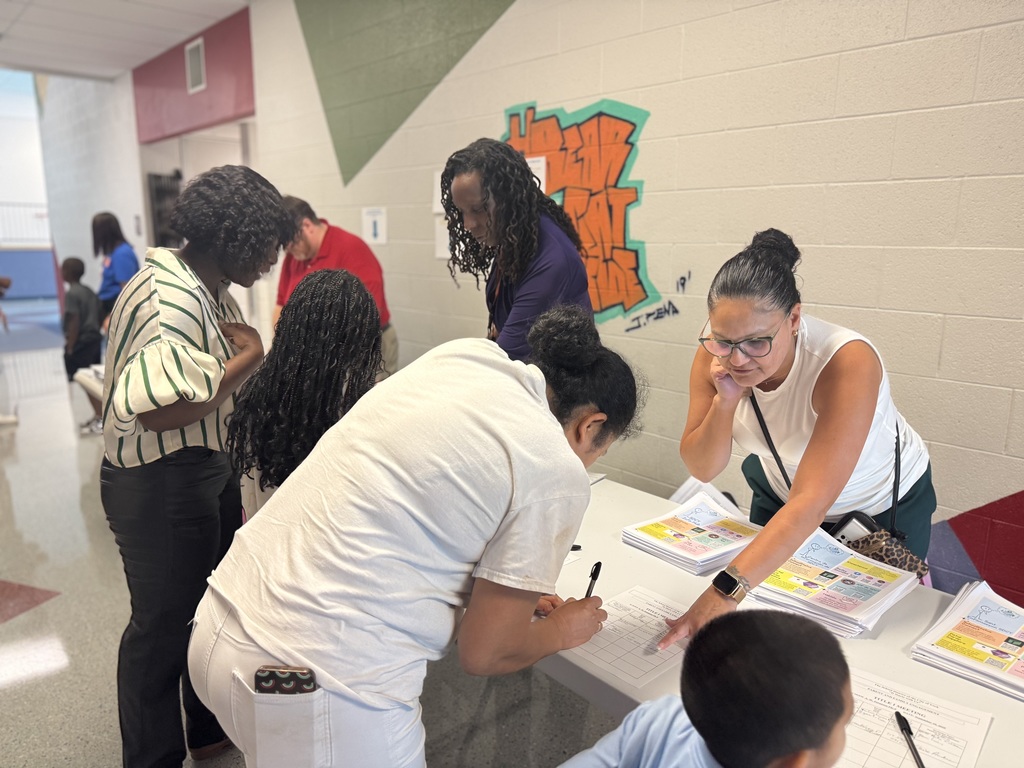 District parent liaisons engaging with parents at a school event. 