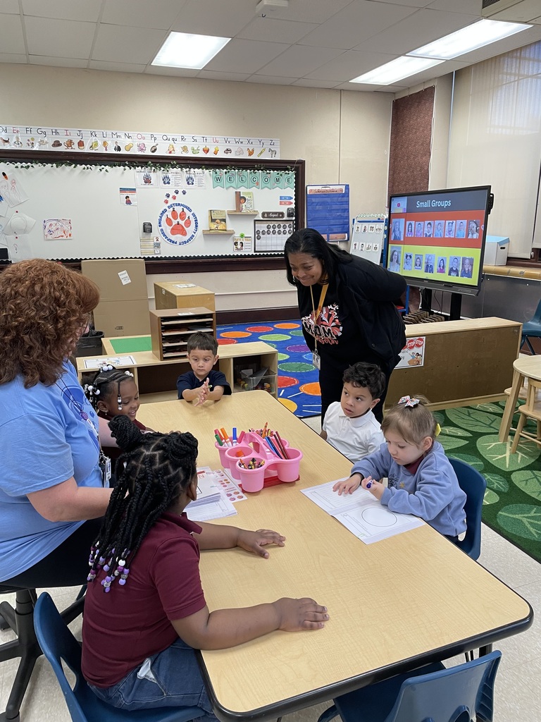 Dr. Andrea Berry-Brown, Superintendent of Schools is observing a group of five students and a teacher in a classroom. The students appear to be engaging in an activity.