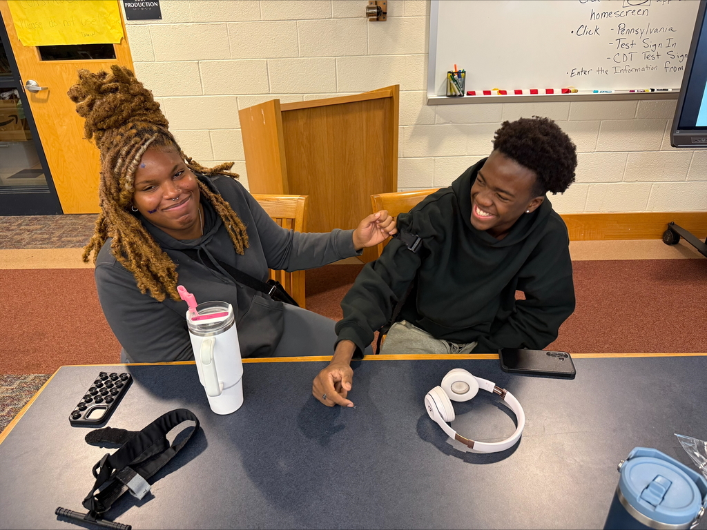Two students are engaging in a Stop the Bleed Training in a school library.