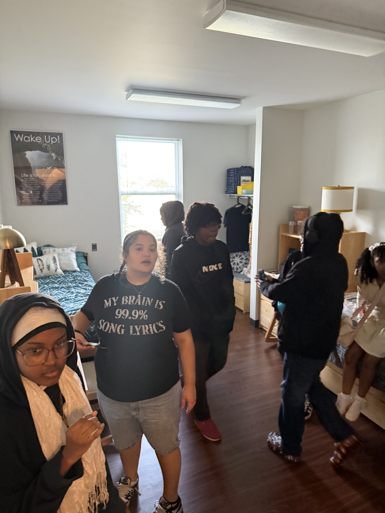 A group of William Penn Senior High School students standing in a dorm room at Millersville University.