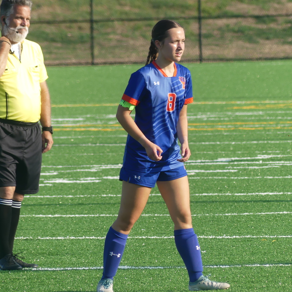 York High Girls Soccer player walking outside on the field.