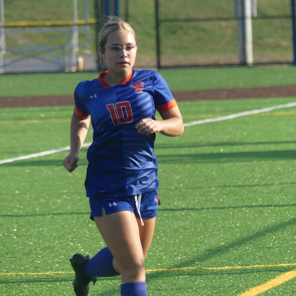 York High Girls Soccer player running outside on the field.