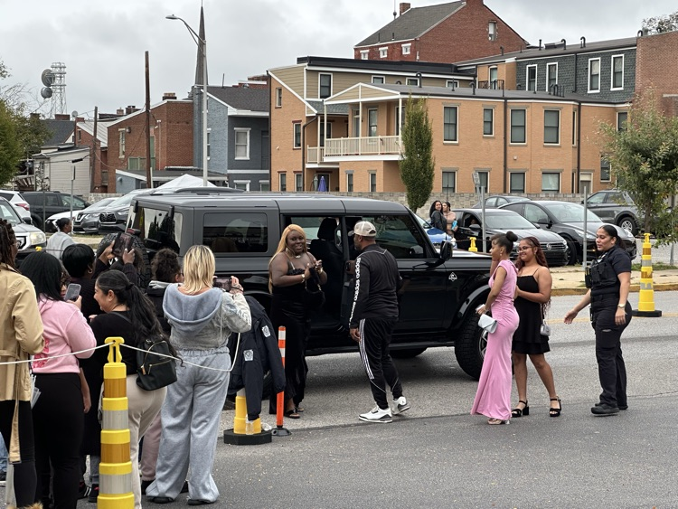 A student is getting out of a car at William Penn Senior High School’s 2025 Homecoming. Cars and other people can be seen in the background.