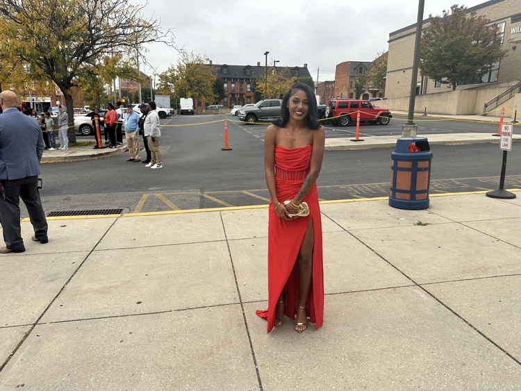 A student is posing outside at William Penn Senior High School’s 2025 Homecoming. Cars and other people can be seen in the background.