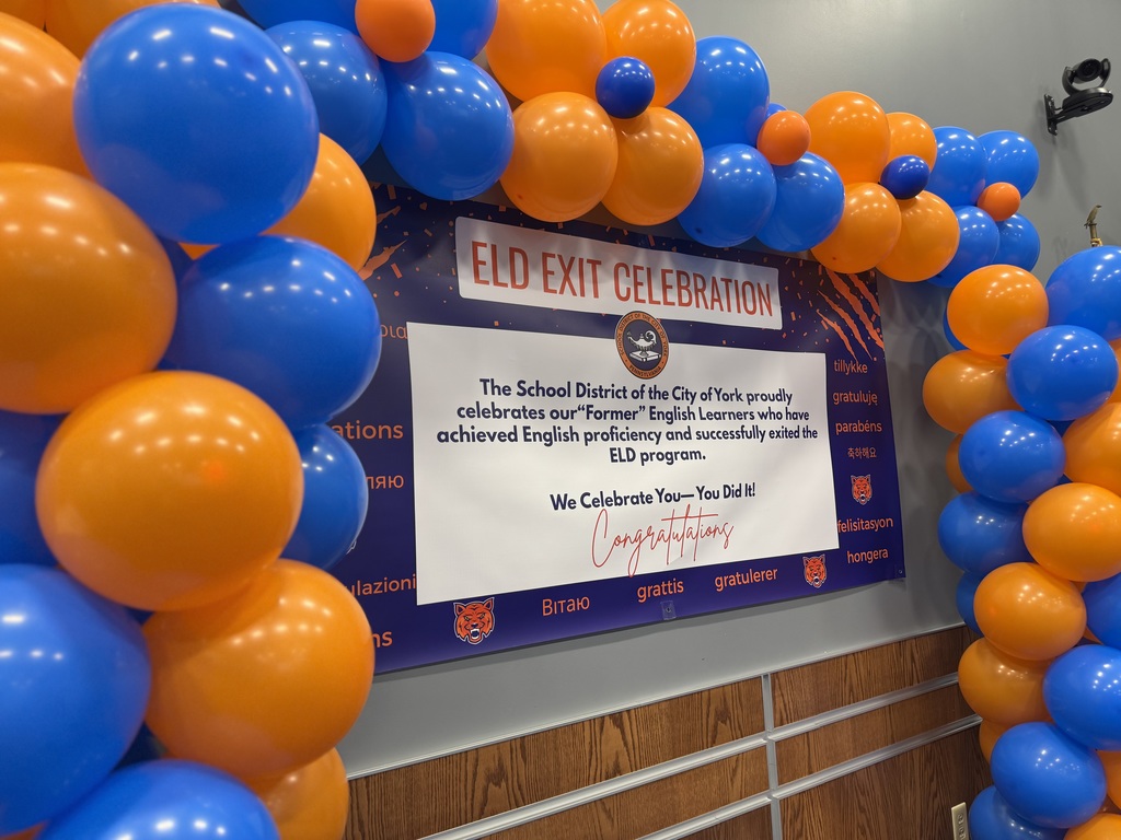 Bright blue and orange balloons surrounding a celebratory banner reading "ELD Exit Celebration." The text below the header reads "The School District of the City of York proudly celebrates our "Former" English Learners who have achieved English proficiency and successfully exited the ELD program. We Celebrate You--You Did It! Congratulations"