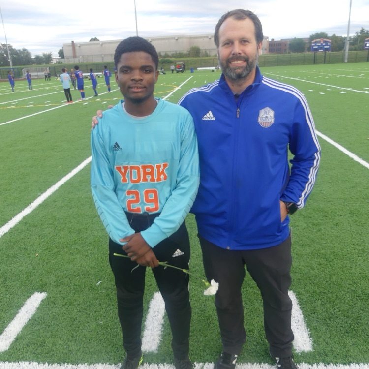 A York High Boys Soccer team player and a man standing