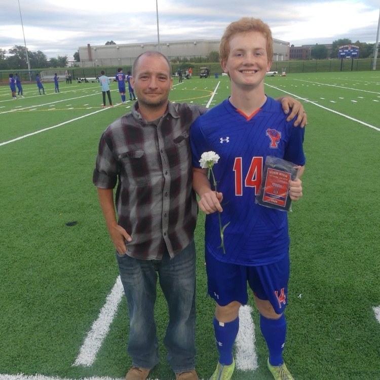 A York High Boys Soccer team player and a man standing