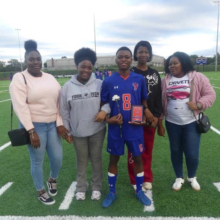 A York High Boys Soccer team player and four women standing