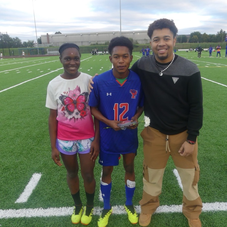 A York High Boys Soccer team player, a man and a teenage girl standing