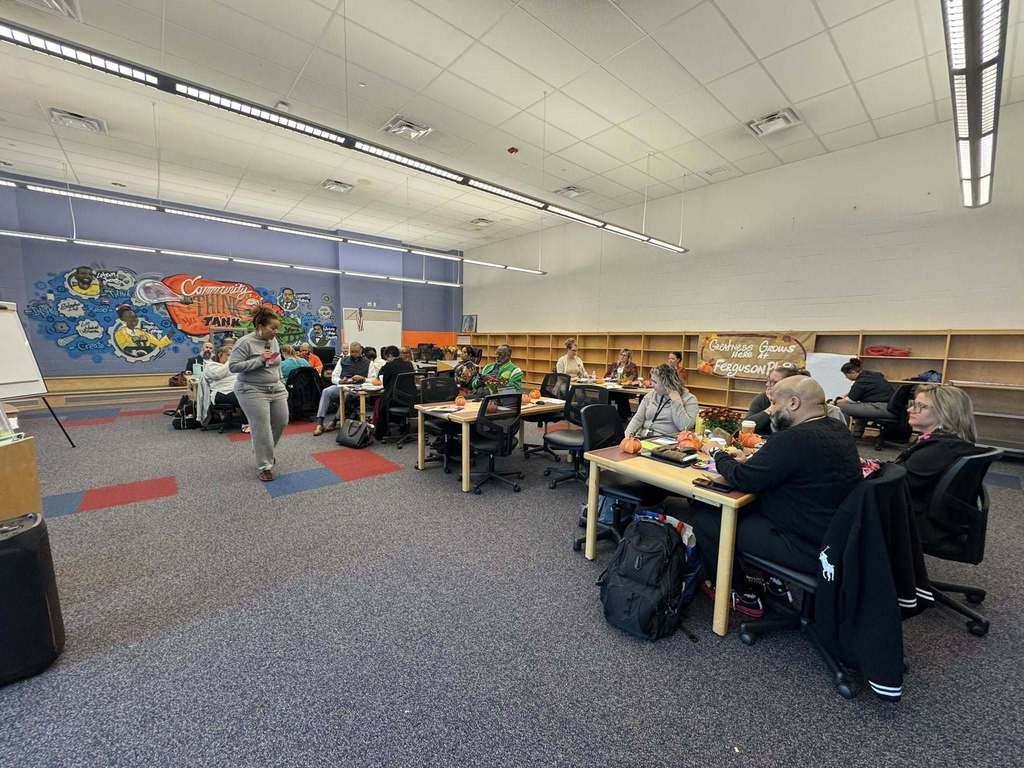 A group of district staff members are having a discussion in a conference room.
