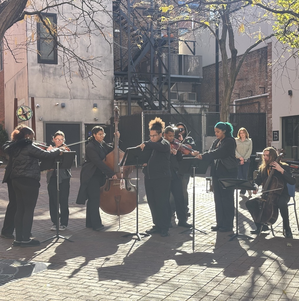 A small ensemble of William Penn Senior High School students are performing outdoors. They are playing strings, including violin and cello.