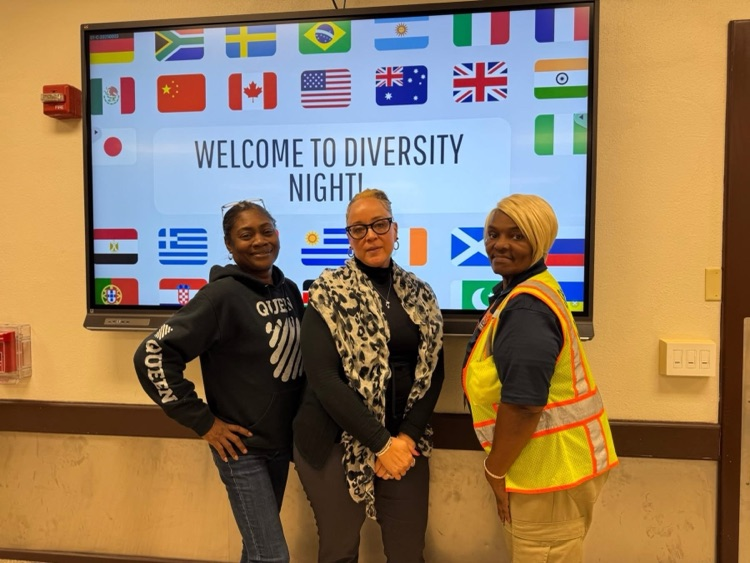 Three district staff members are standing in front of a screen that says “Welcome to Diversity Night!"