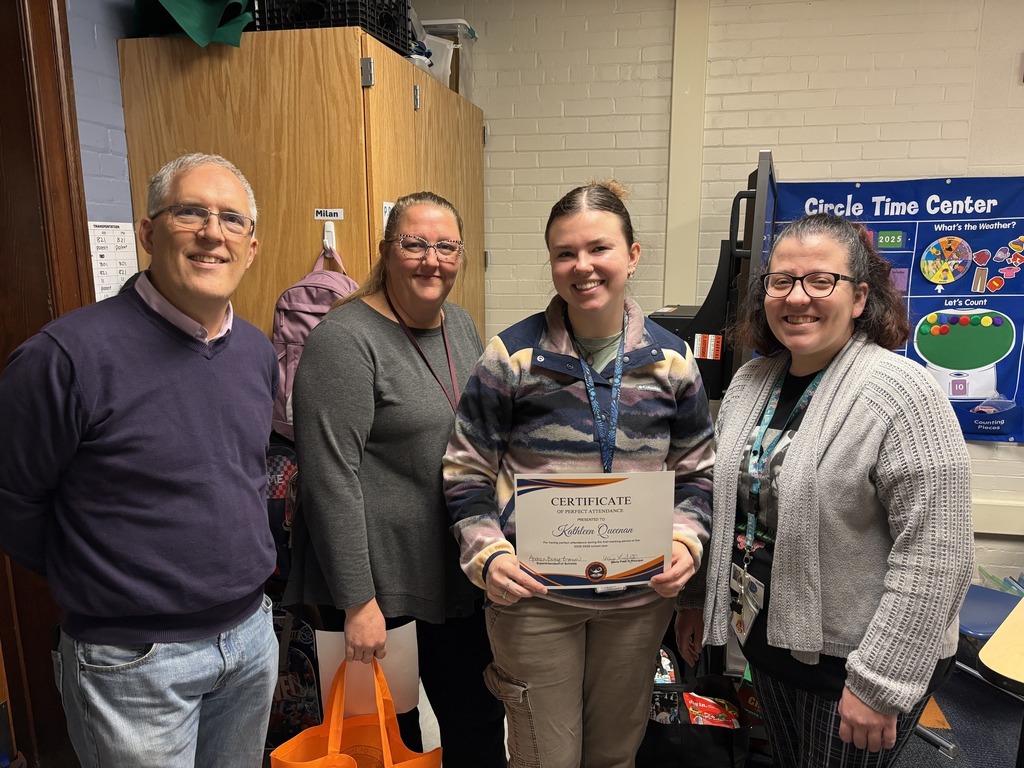 Davis PreK-8's Principal and Assistant Principal, Ms. Mindy Sweitzer and Dr. Stefanie Moyar, are standing with a district staff member and a community member in a school classroom. The district staff member is holding a certificate in her hand.