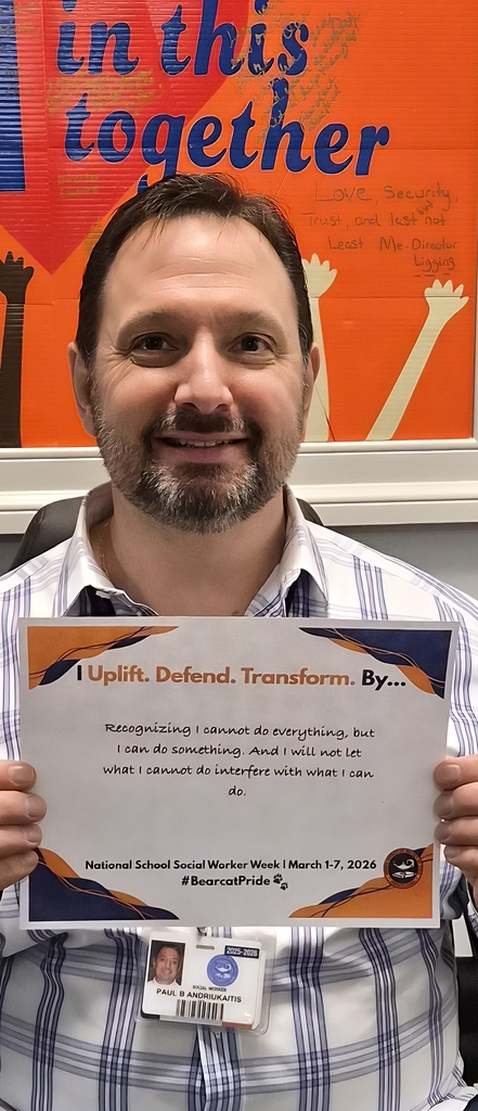A district staff member is holding a sign that says "I Uplift. Defend. Transform. By... Recognizing I cannot do everything, but I can do something. And I will not let what I cannot do interfere with what I can do."