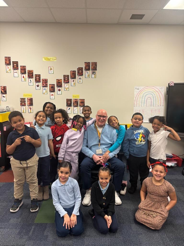 Mr. Rob Bernhard and a classroom of students are taking a group photo 