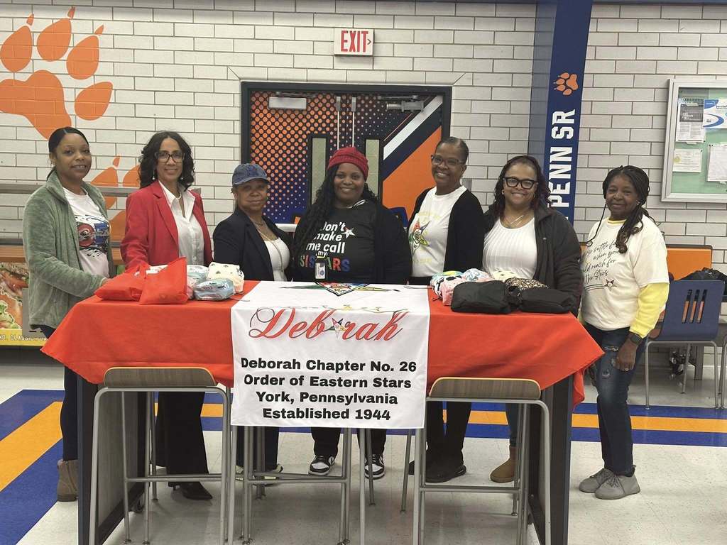 Seven women are standing behind a table in a school cafeteria that reads "Deborah Chapter No. 26, Order of Eastern Stars, York, Pennsylvania, Established 1944."
