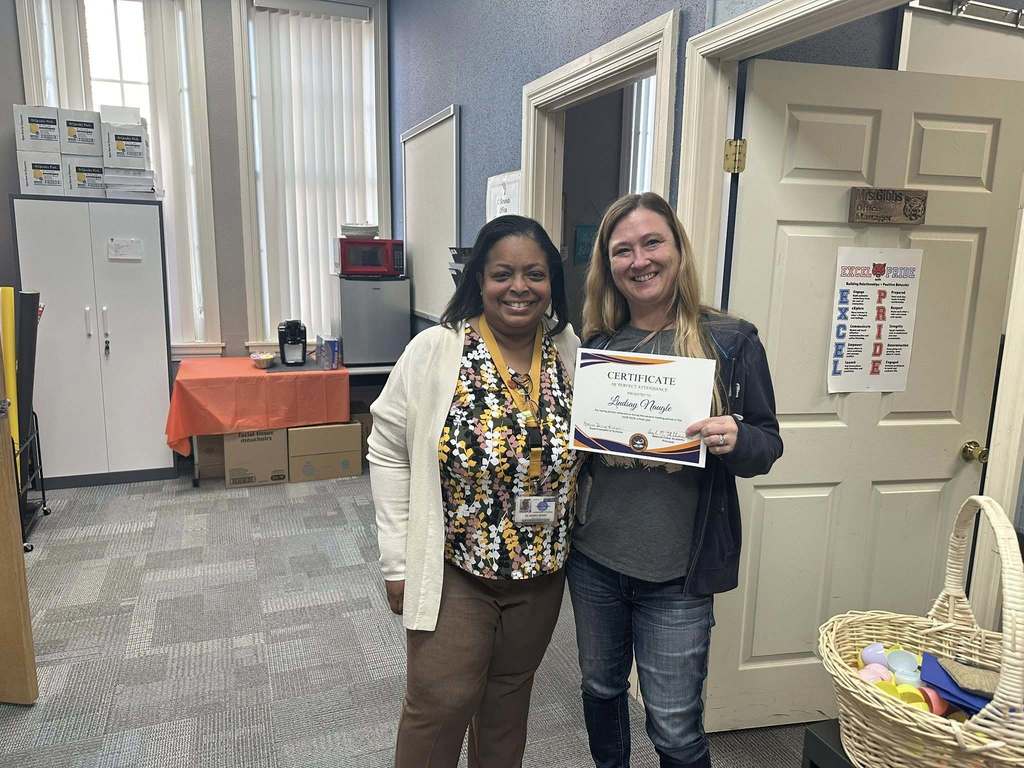 Dr. Andrea Berry-Brown, Superintendent of Schools, is standing next to a district staff member who is holding a Perfect Attendance certificate for the second marking period.