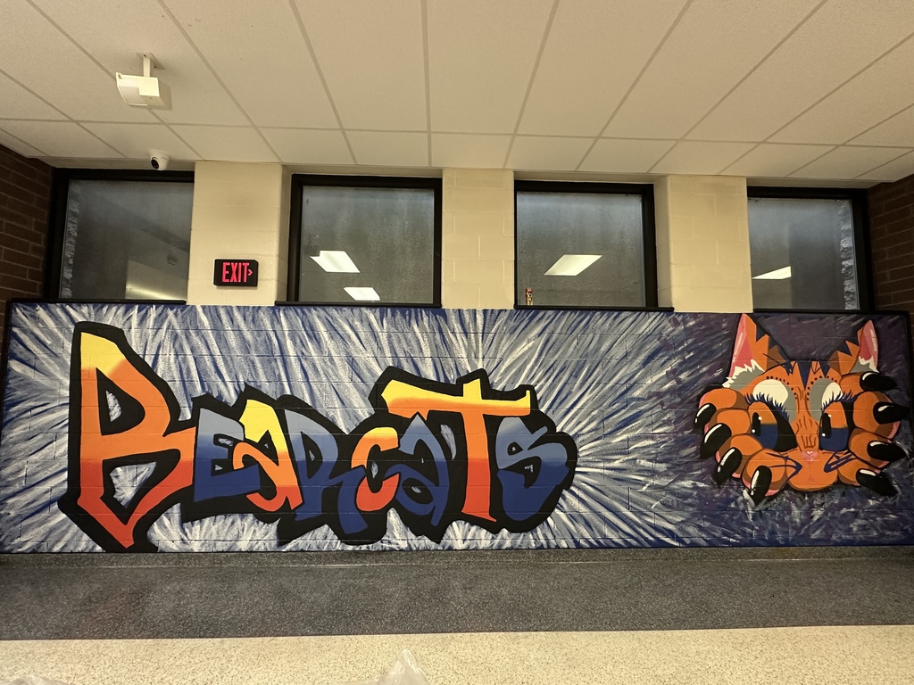 A colorful school hallway mural features the word "Bearcats" in bold graffiti-style lettering alongside a fierce bearcat illustration with bright orange, blue, and black accents.