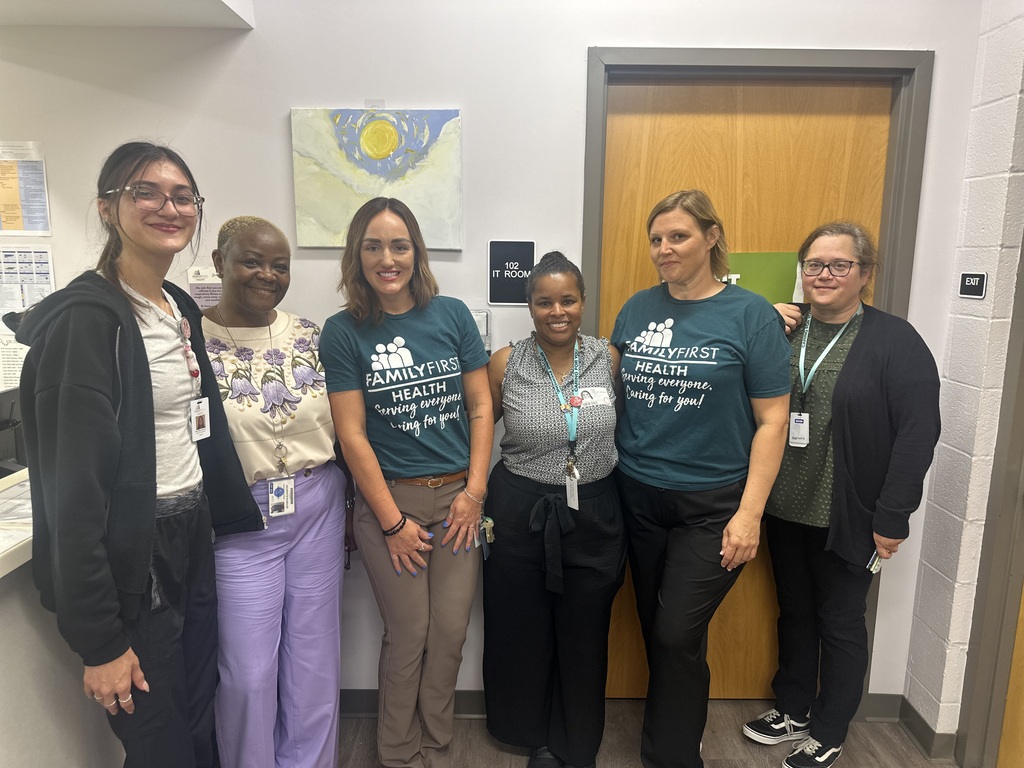 Dr. Portia Slaughter, Assistant Superintendent is posing with a group of Family First Health staff members in a lobby area.