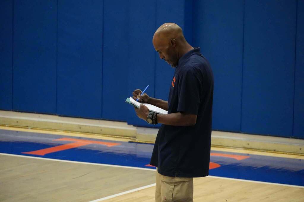 One of the York High Volleyball coaches is writing on a piece of paper. 