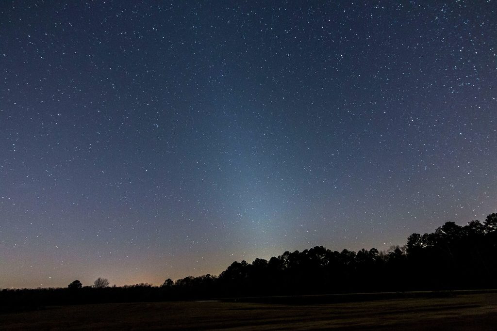 On moonless evenings this month, see if you can spot the zodiacal light. This dim glow, aligned with the ecliptic, extends steeply above the western horizon well after the low arc of the twilight glow has diminished. From completely dark locations, the zodiacal light is almost as bright as the Milky Way. The cone extends upward through Aquarius, Pisces, and Aries. A line connecting Mercury and Saturn shows the way. Scan your eyes left and right and your peripheral vision will pick up the cone-shaped glow. SOURCE: astronomy.com