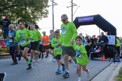 A man holds hands with two children at the start of a race