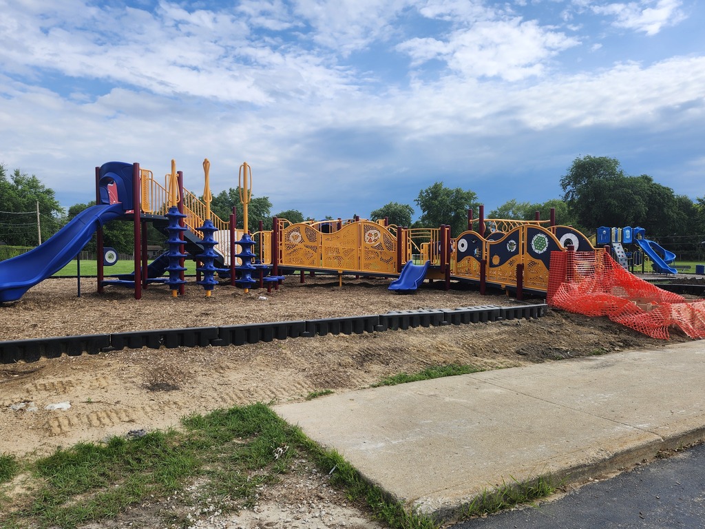 Playground with a blue slide, a blue climbing frame, and a red safety net. Playground is still under construction.