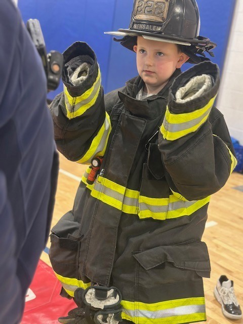 A student tries on the fireman's suit!