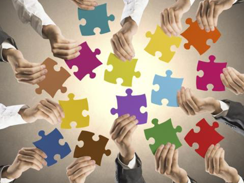 (image of peoples hands holding puzzle pieces to connect and fit together)
