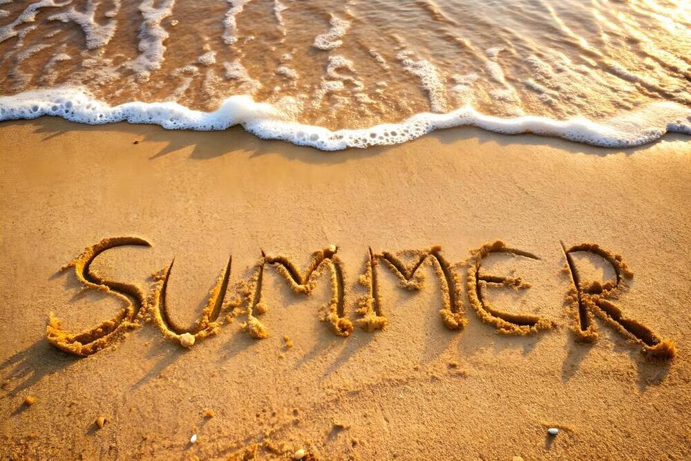 Image of a beach with "summer" carved into the sand