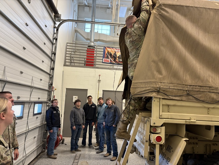 Students taking a look inside a truck at the National Guard Armory.