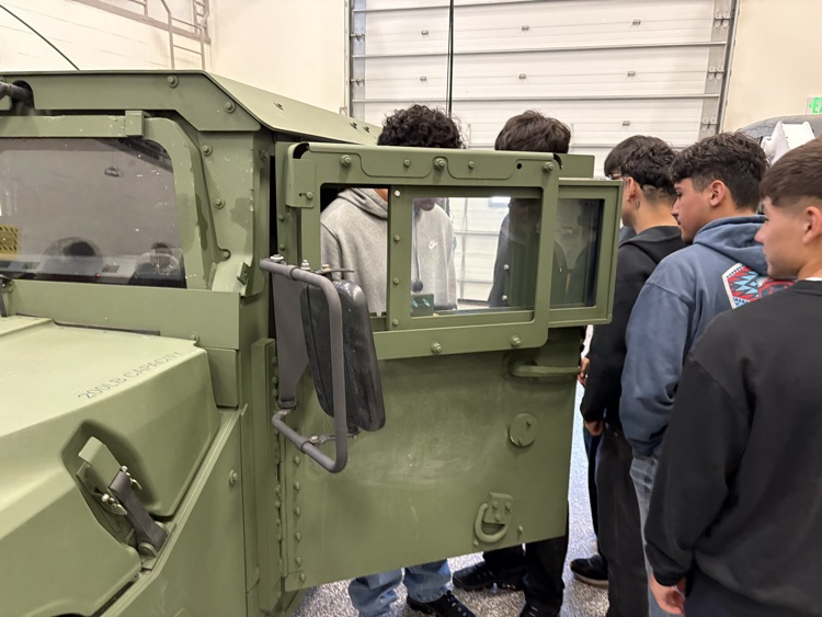 Students looking inside of vehicle at the National Guard Armory.