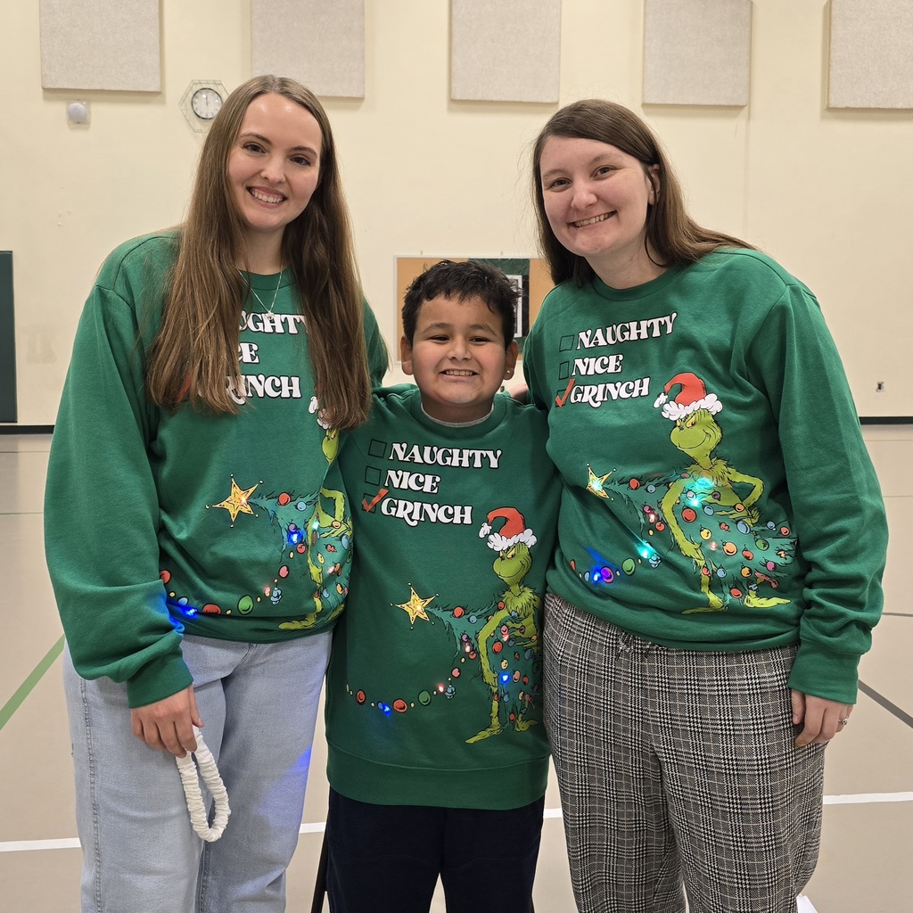 Two teachers and a student in matching Grinch sweaters