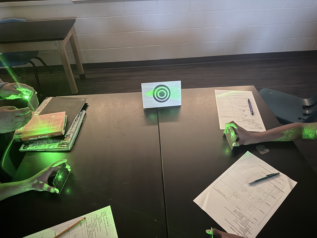 Students in action exploring the properties of light using laser pointers and mirrors.  Discovering how light reflects and changes direction through hands-on learning!