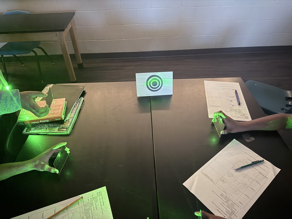 Students in action exploring the properties of light using laser pointers and mirrors.  Discovering how light reflects and changes direction through hands-on learning!