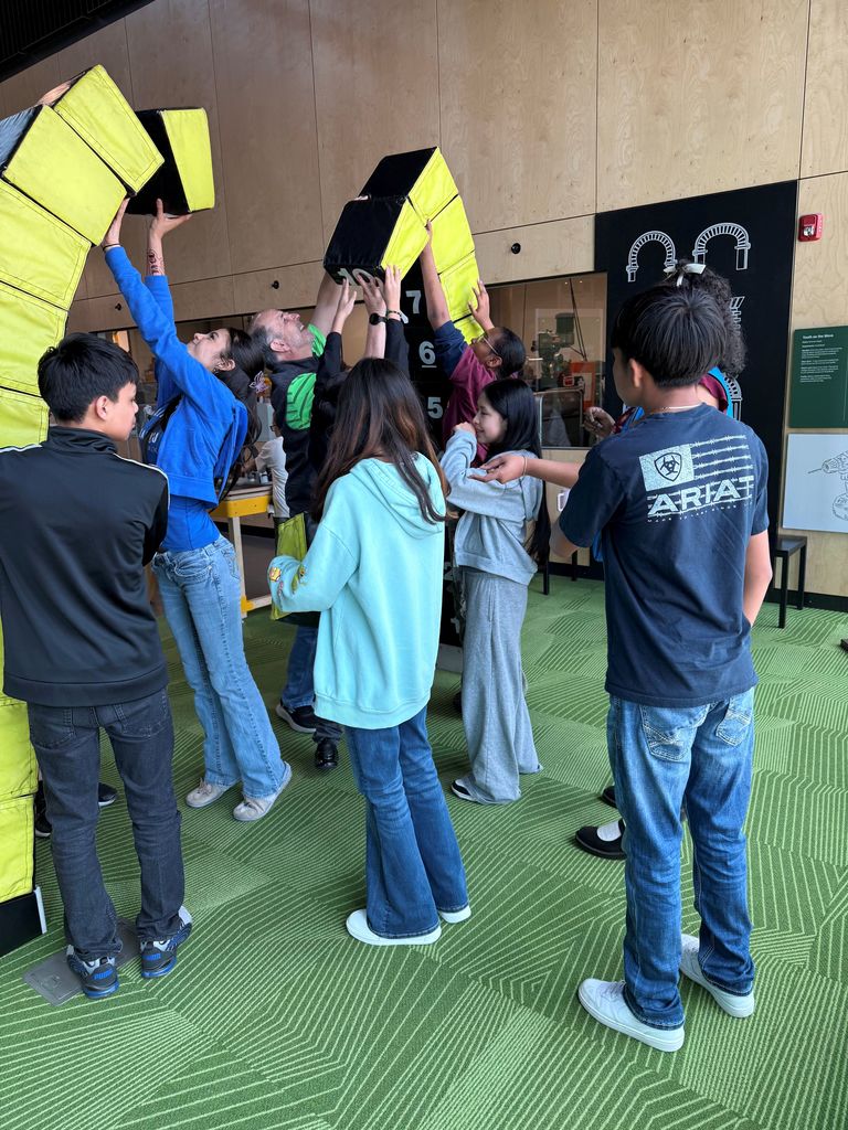 Students and teacher trying to build and arch.
