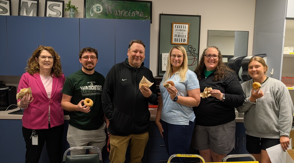 SMS Principal and teachers enjoying donuts  from Pinnacle Bank.