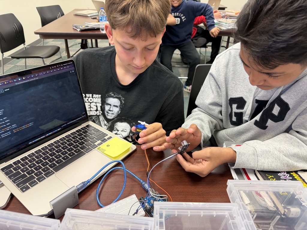 Students work together to test and program electronic components, turning coding and engineering concepts into hands-on innovation.
