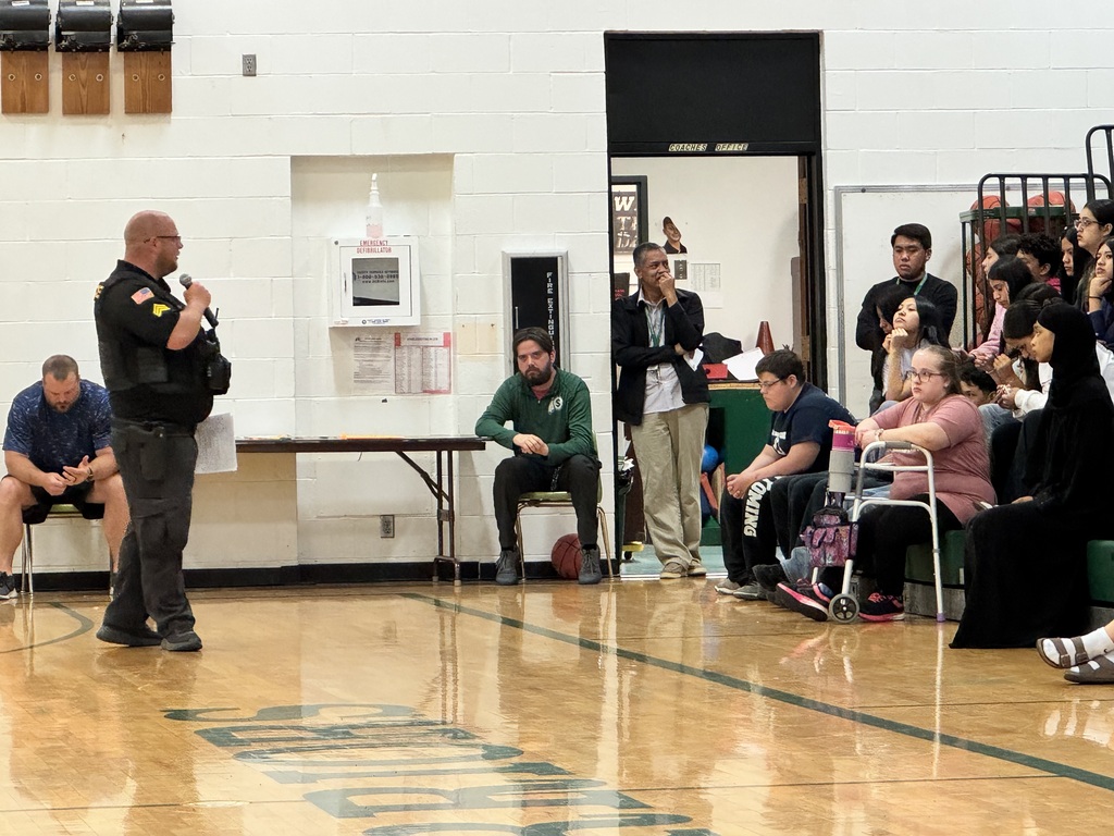 Officer Terrell leading an assemly about Online Safety as students watch.